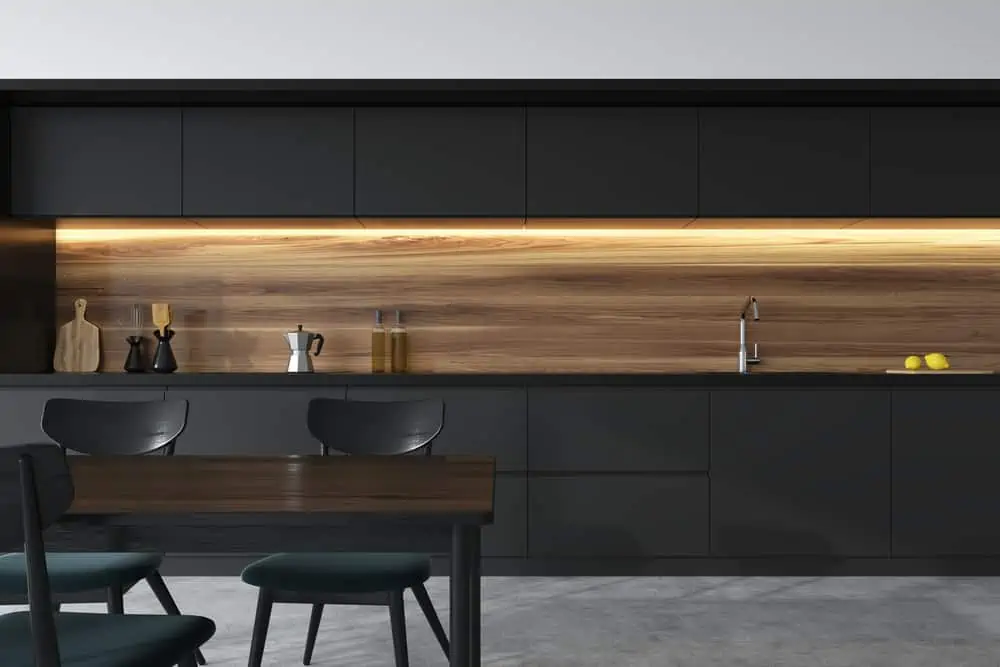 Front view of a panoramic black and wooden kitchen interior with dark gray countertops and a table with chairs. 3d rendering mock up