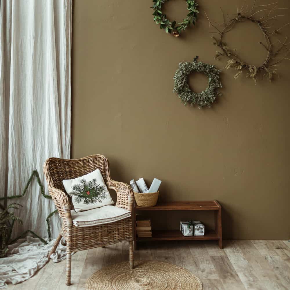 Round homemade wreath frames made of fir needles and branches on olive wall. Christmas celebration decoration. New Year composition. Modern interior design.
