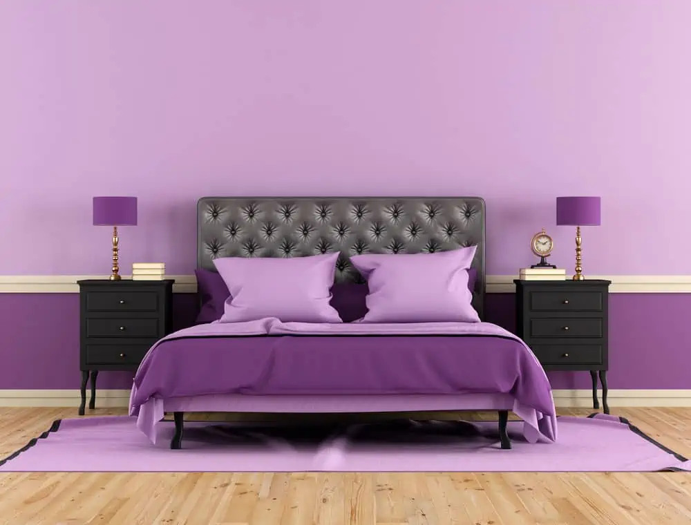 Black and purple bedrrom with double bed and nightstand