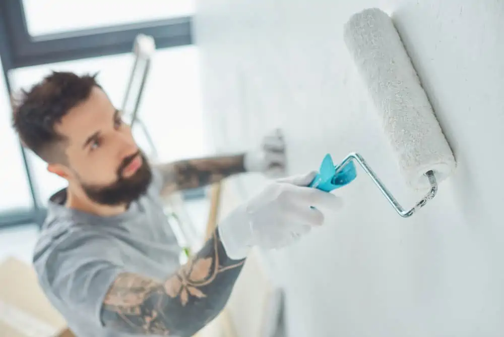 selective focus of repairman with roll paint brush