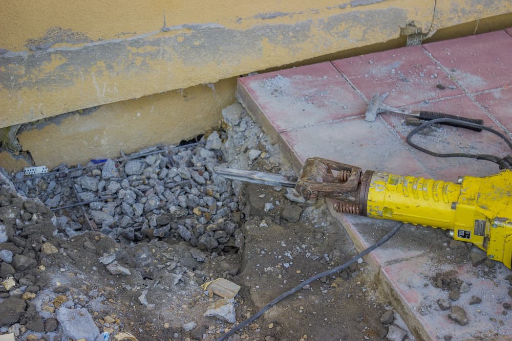 sidewalk crack repairing works with electric jackhammer