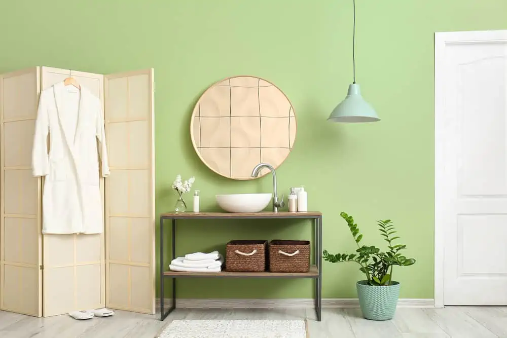 Interior of stylish bathroom with table and folding screen