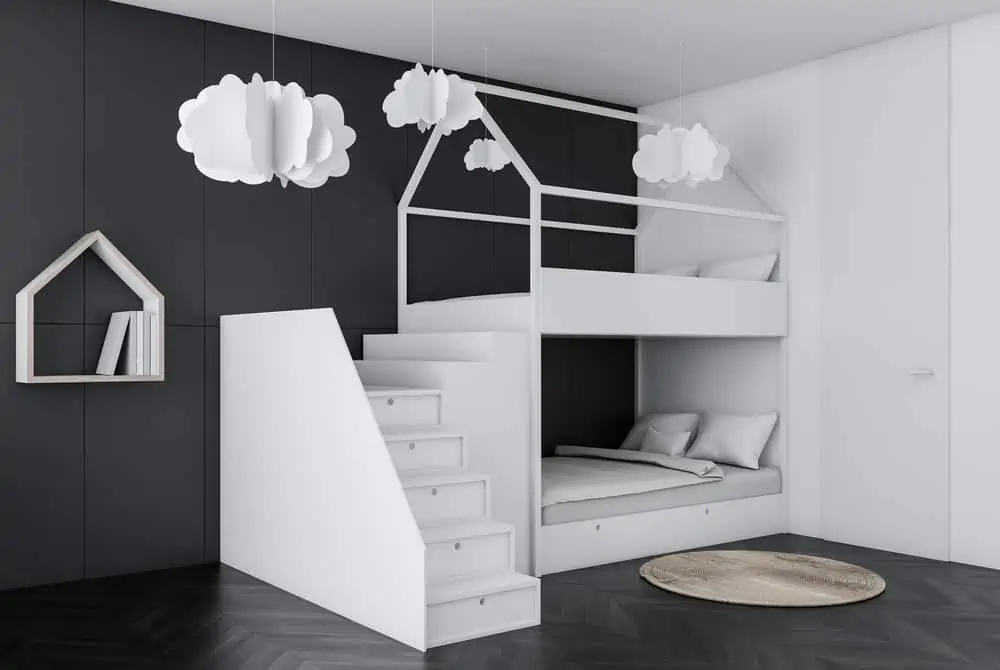 Corner of kids bedroom with gray walls, dark wooden floor, white bunk bed and house shaped bookshelf. Paper clouds. 3d rendering