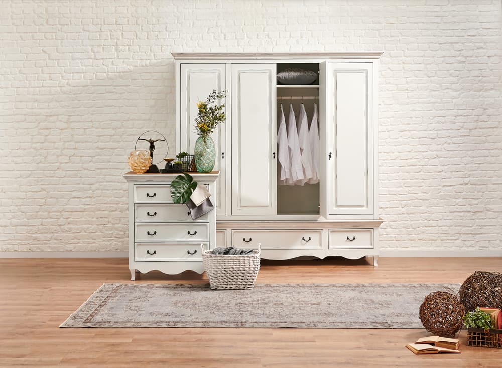 White classic drawer and wardrobe in the bed room and white brick wall background.