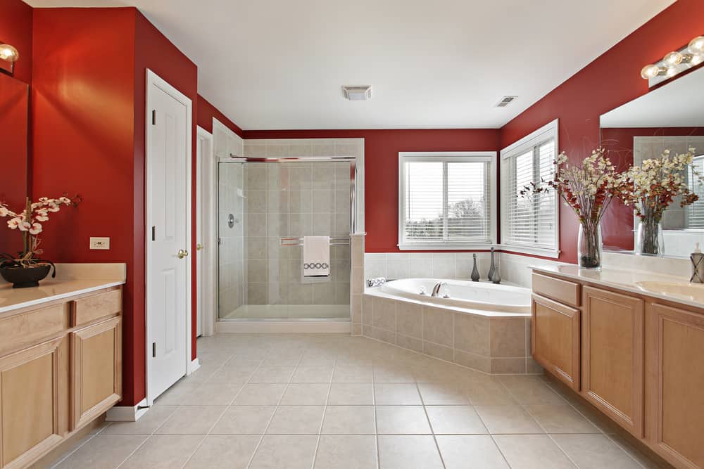 Large master bath with red walls and glass shower