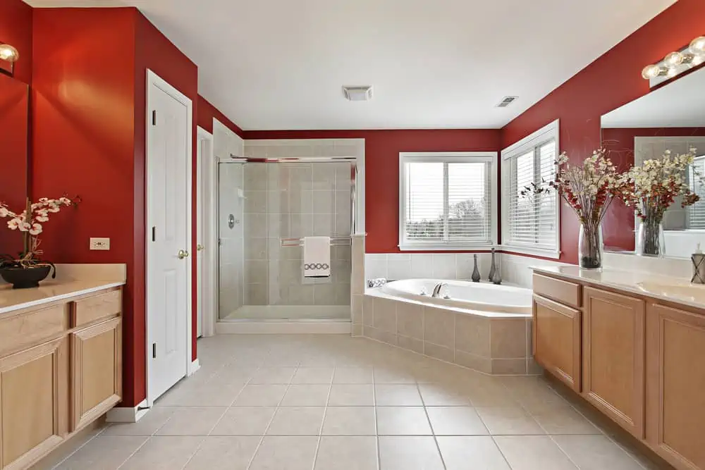 Large master bath with red walls and glass shower