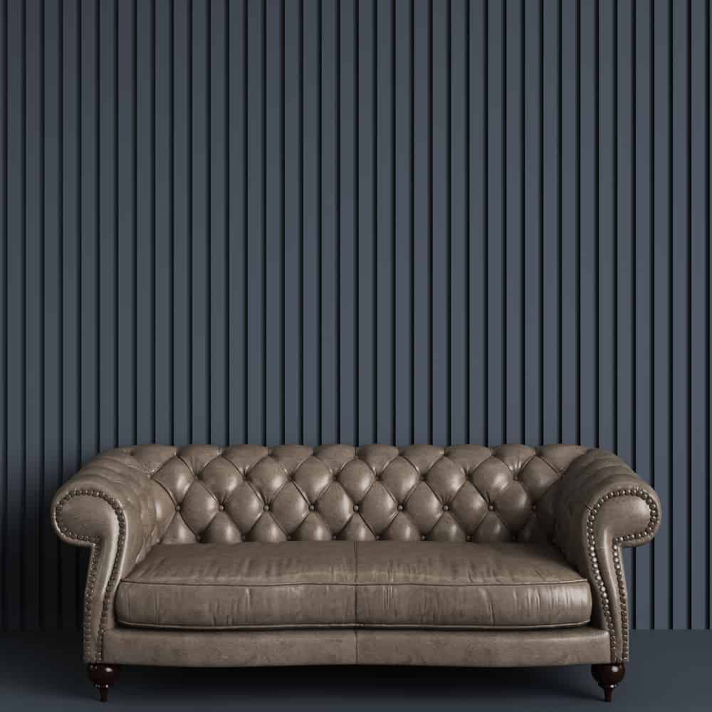 Classic tufted sofa in gray empty room with relief stripe wall. Minimal concept.Digital Illustration.3d rendering