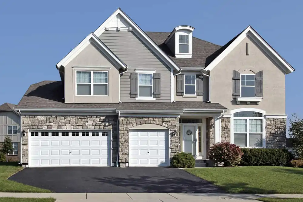 Home in suburbs with three car stone garage