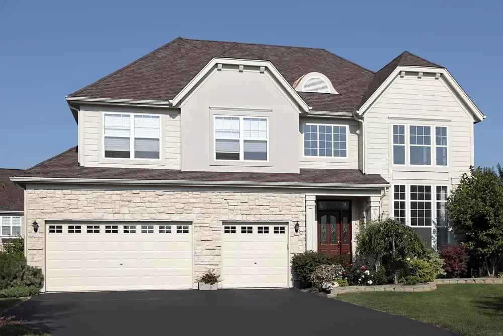 Home in suburbs with three car stone garage