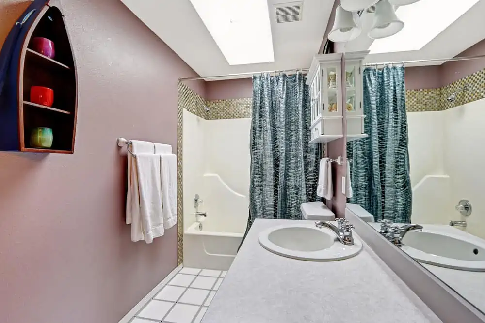 Simple bathroom intrerior in mauve color with skylight