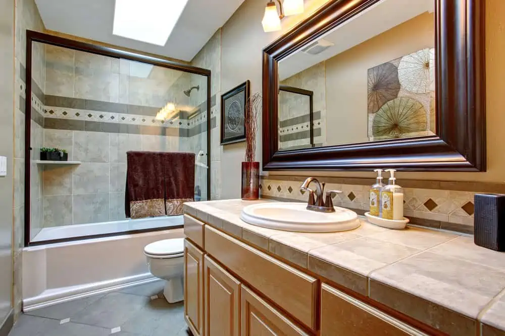 Elegant bathroom with glass shower, large framed mirror, and great decor.