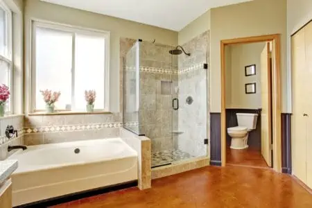 Bathroom interior with white bath tub, glass door shower and toilet