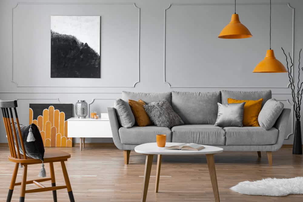Comfortable grey sofa with pillows in elegant living room with scandinavian design