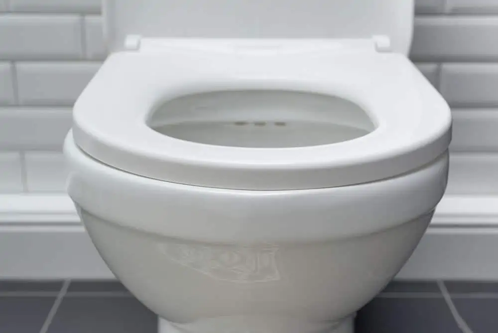 Close-up image of white ceramic toilet bowl in the bathroom interior