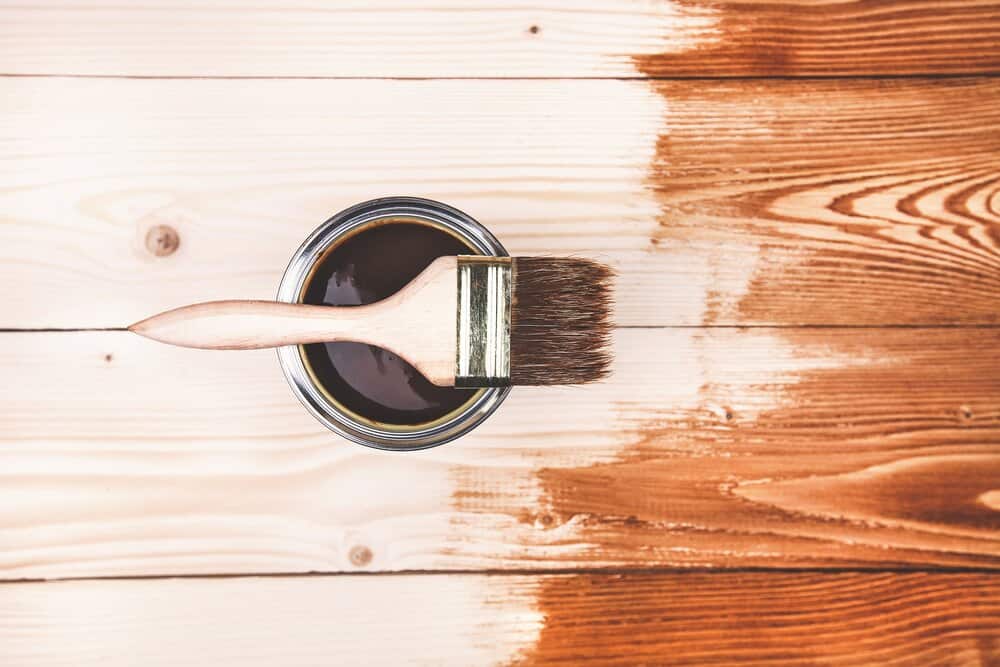 Varnishing a wooden deck using paintbrush