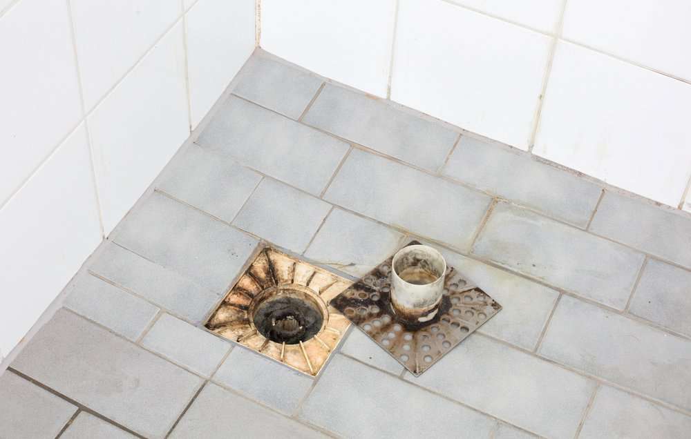 Dirty shower floor drain in an old shower