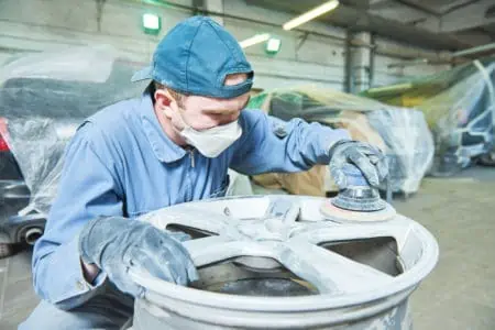 Repair mechanic worker with light alloy car wheel disk rim