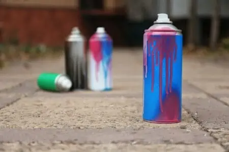 Used can of colorful spray paint on driveway