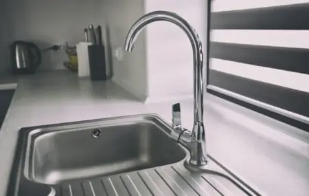 Metal faucet in the modern gray kitchen