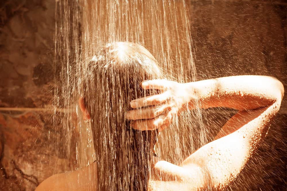 Woman touching her hair while showering