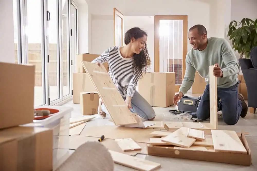 Happy couple putting together self assembly furniture