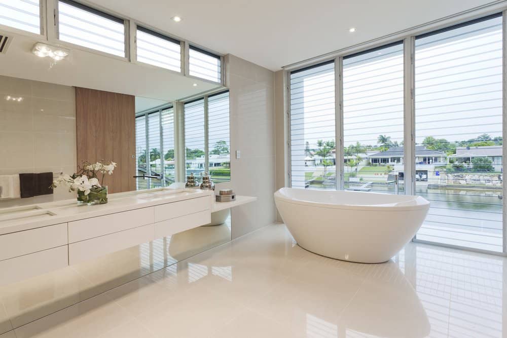 Modern bathroom with white bathtub and white countertop in luxury house