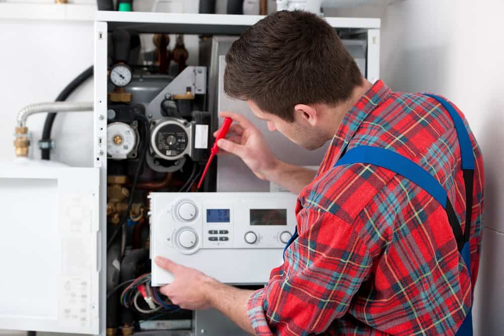 Male technician servicing the gas boiler for hot water and heating