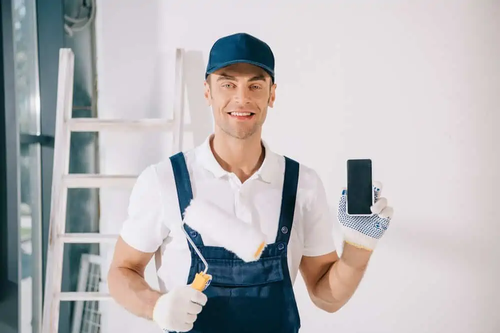 Professional painter holding paint roller and device